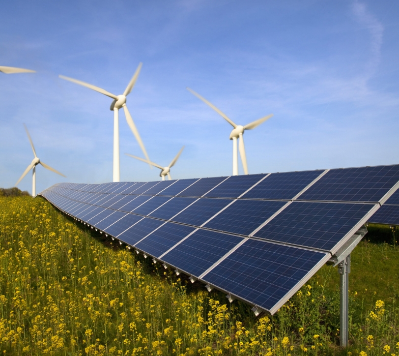 Solar panels and wind turbines in field
